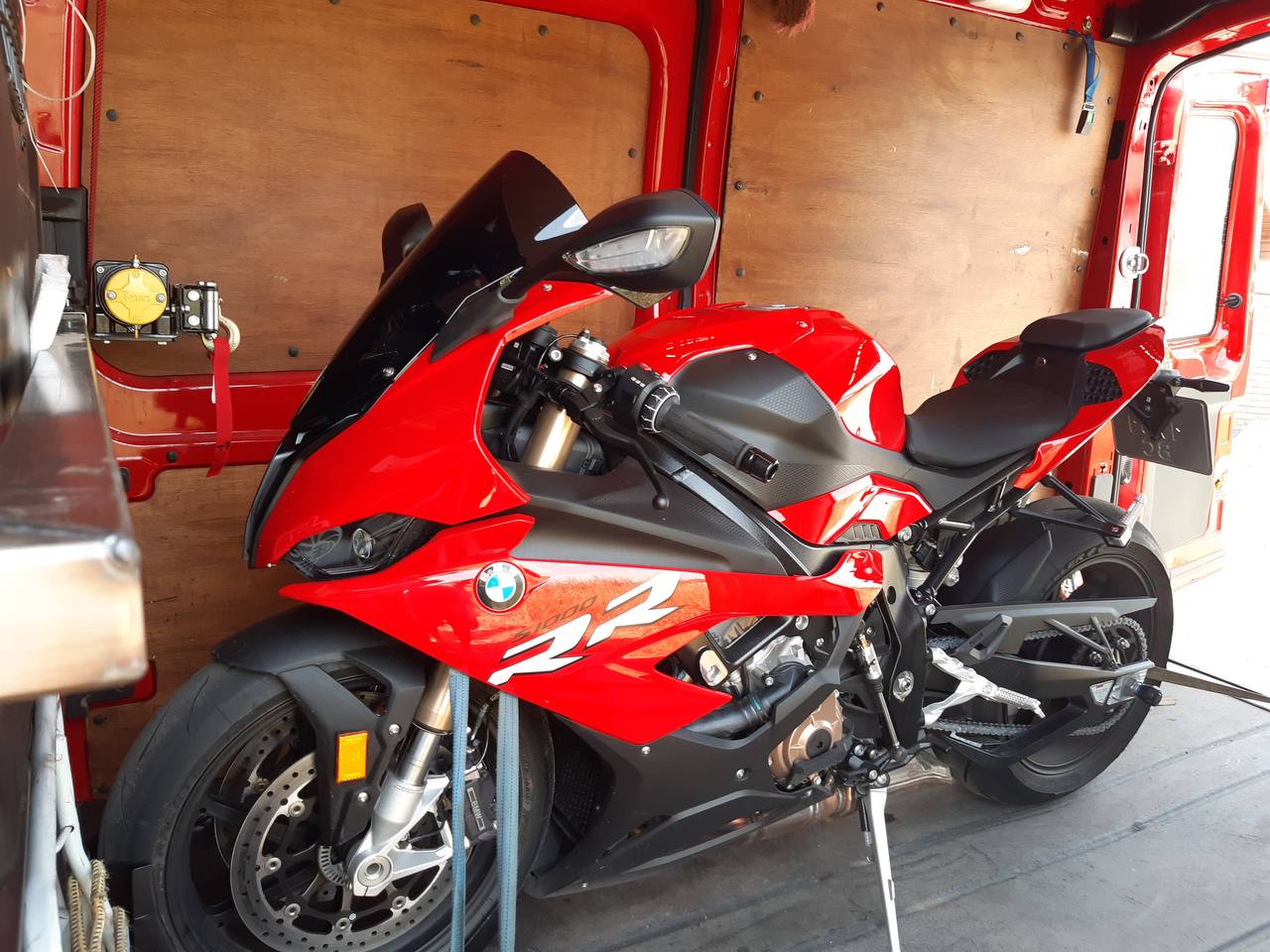 Етапи перевезення мототехніки. Видно процес завантаження, кріплення та транспортування.